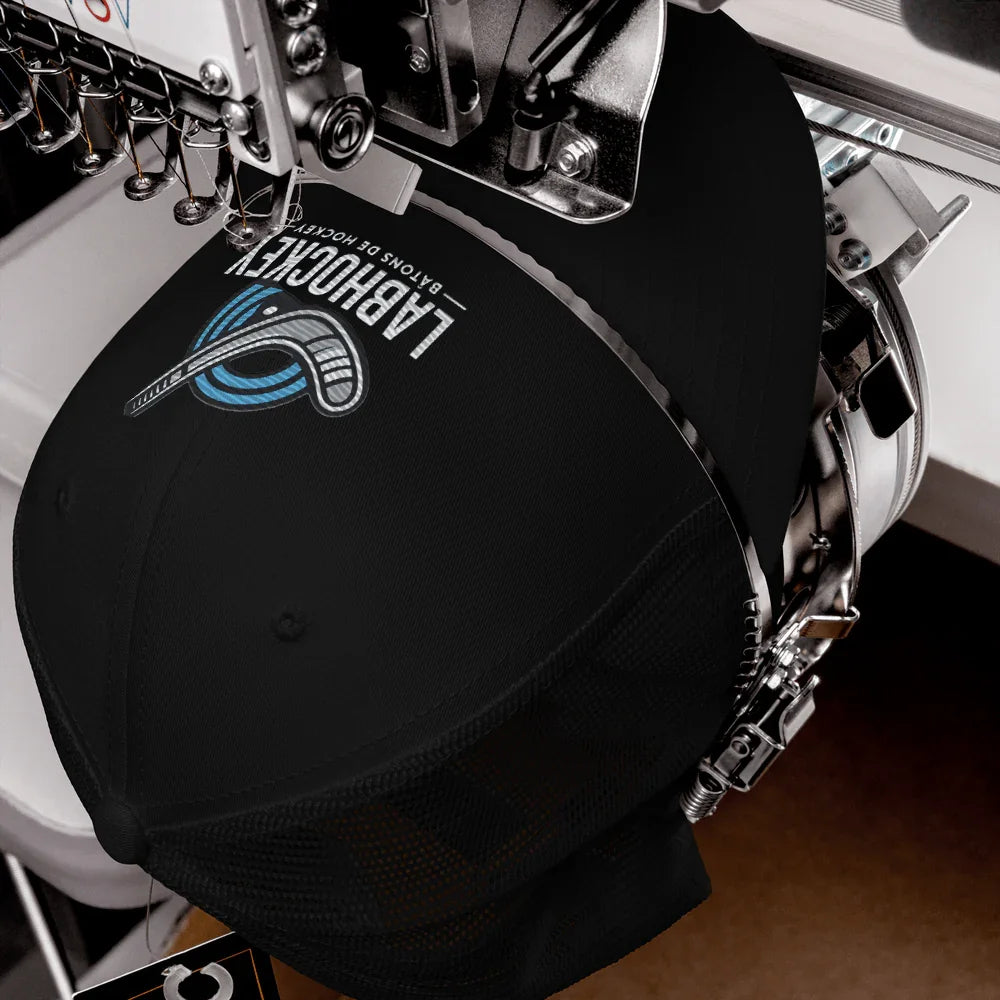 Casquette trucker noire LabHockey brodée en machine, logo bâtons de hockey visible.